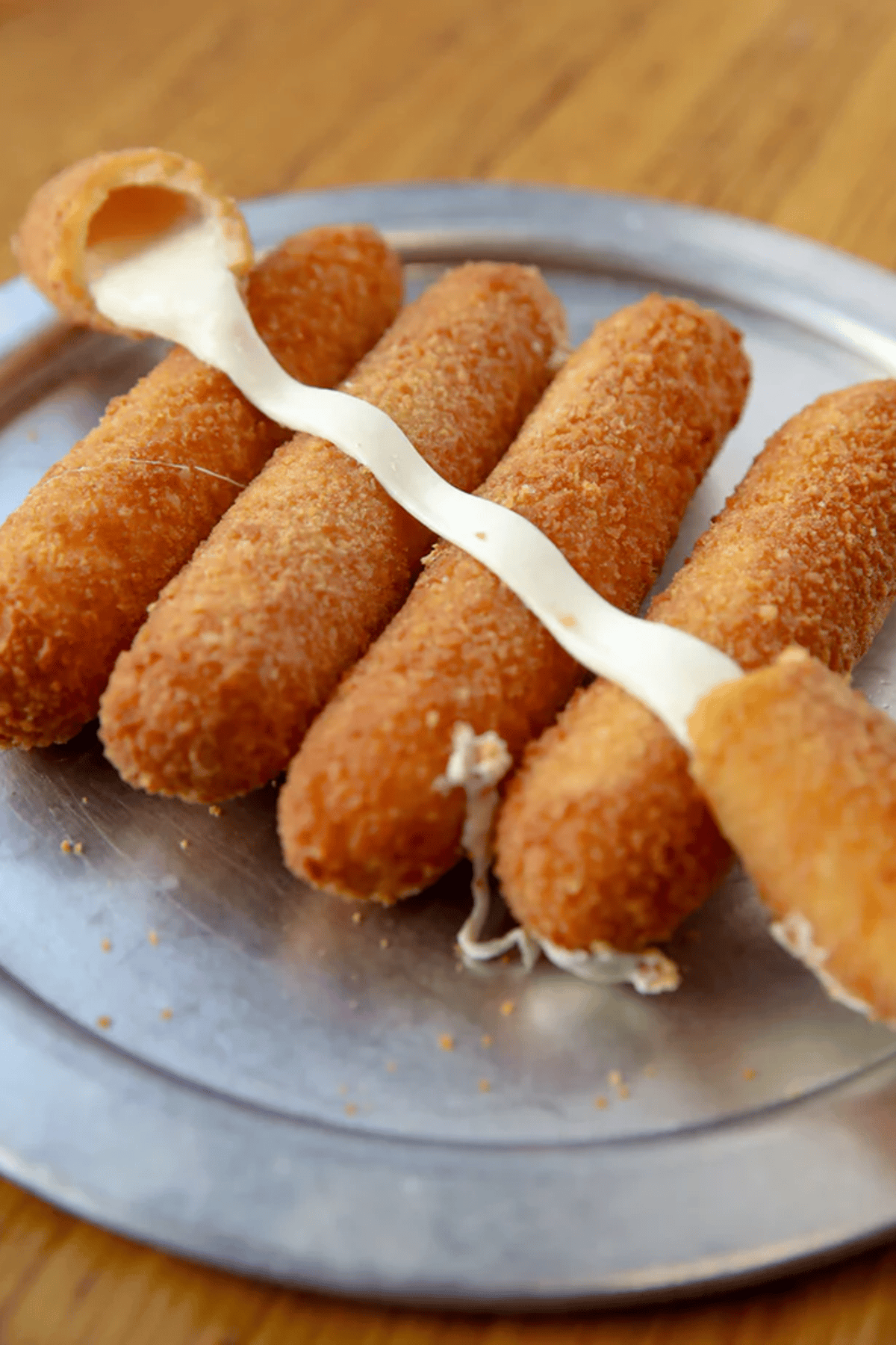 Hand holding mozzarella stick