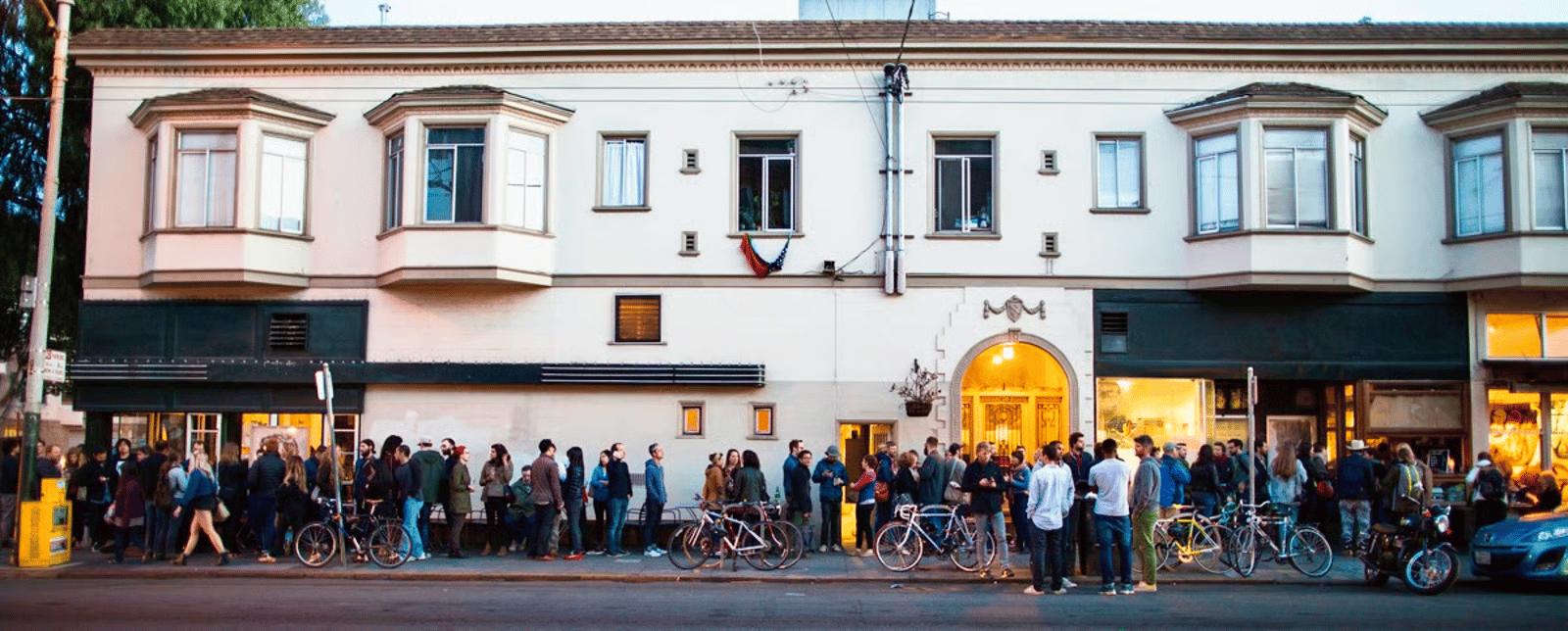 People and bicycles lining the sidewalk outside Tartine in San Francisco