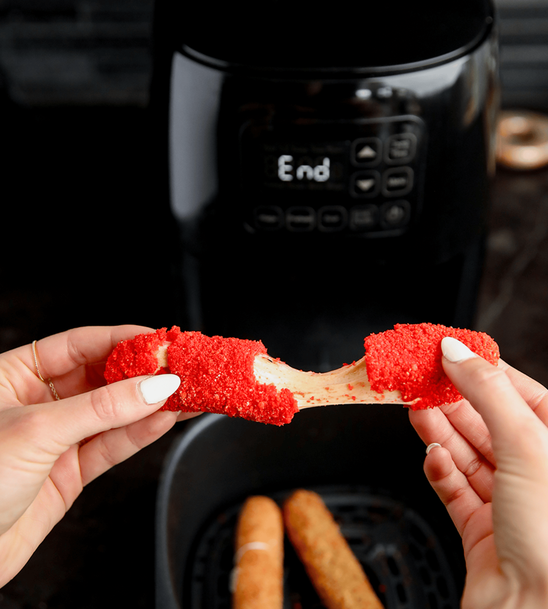 Mozzarella sticks being pulled from the oven