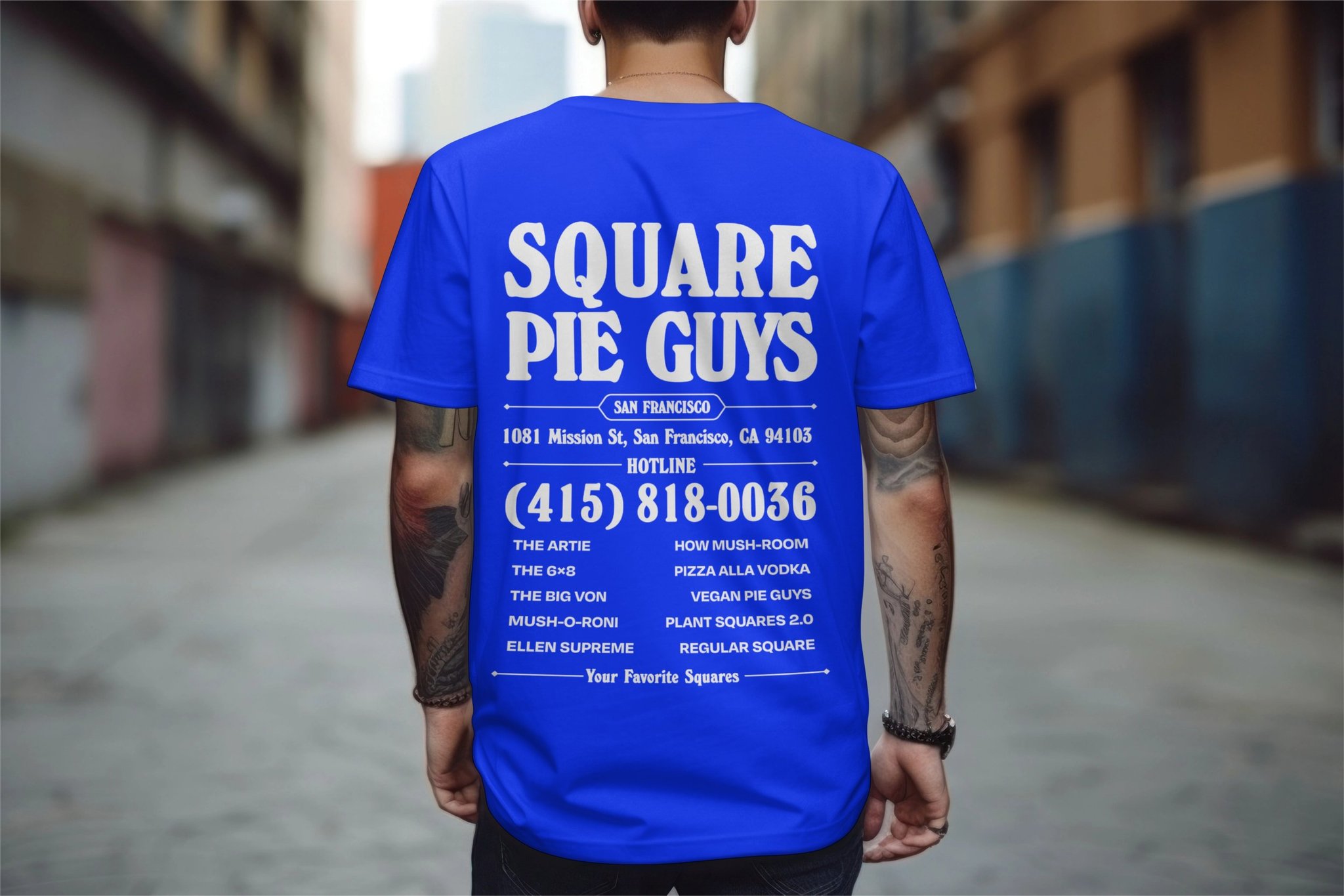 Back of a person wearing a blue T-shirt with white text advertising Square Pie Guys.