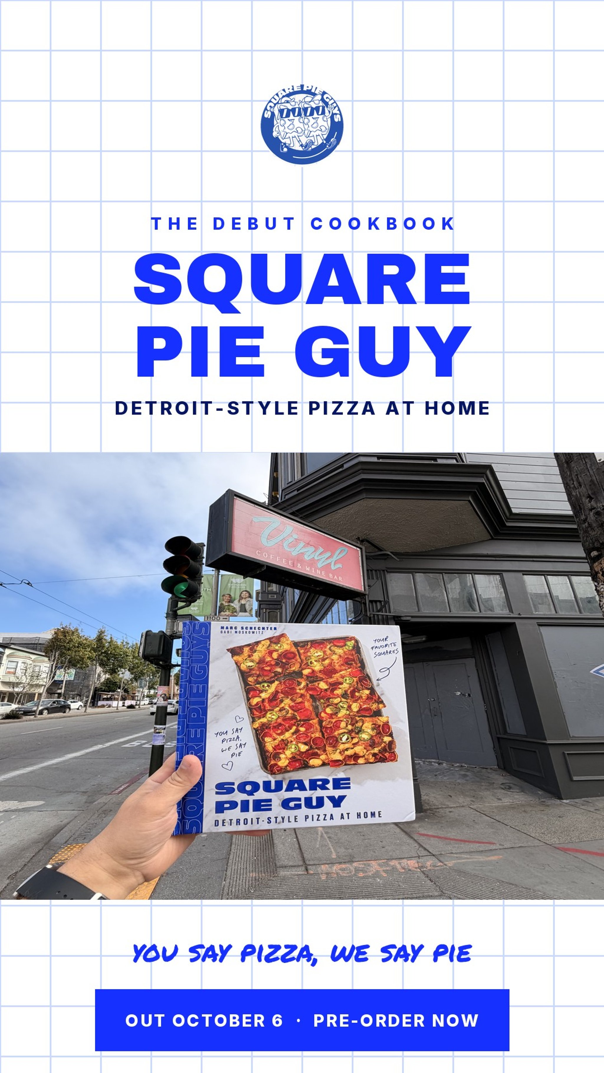 A hand holding the Square Pie Guy: Detroit-Style Pizza at Home cookbook in front of Vinyl Coffee & Wine Bar in San Francisco — where Square Pie Guys began as a pop-up.
