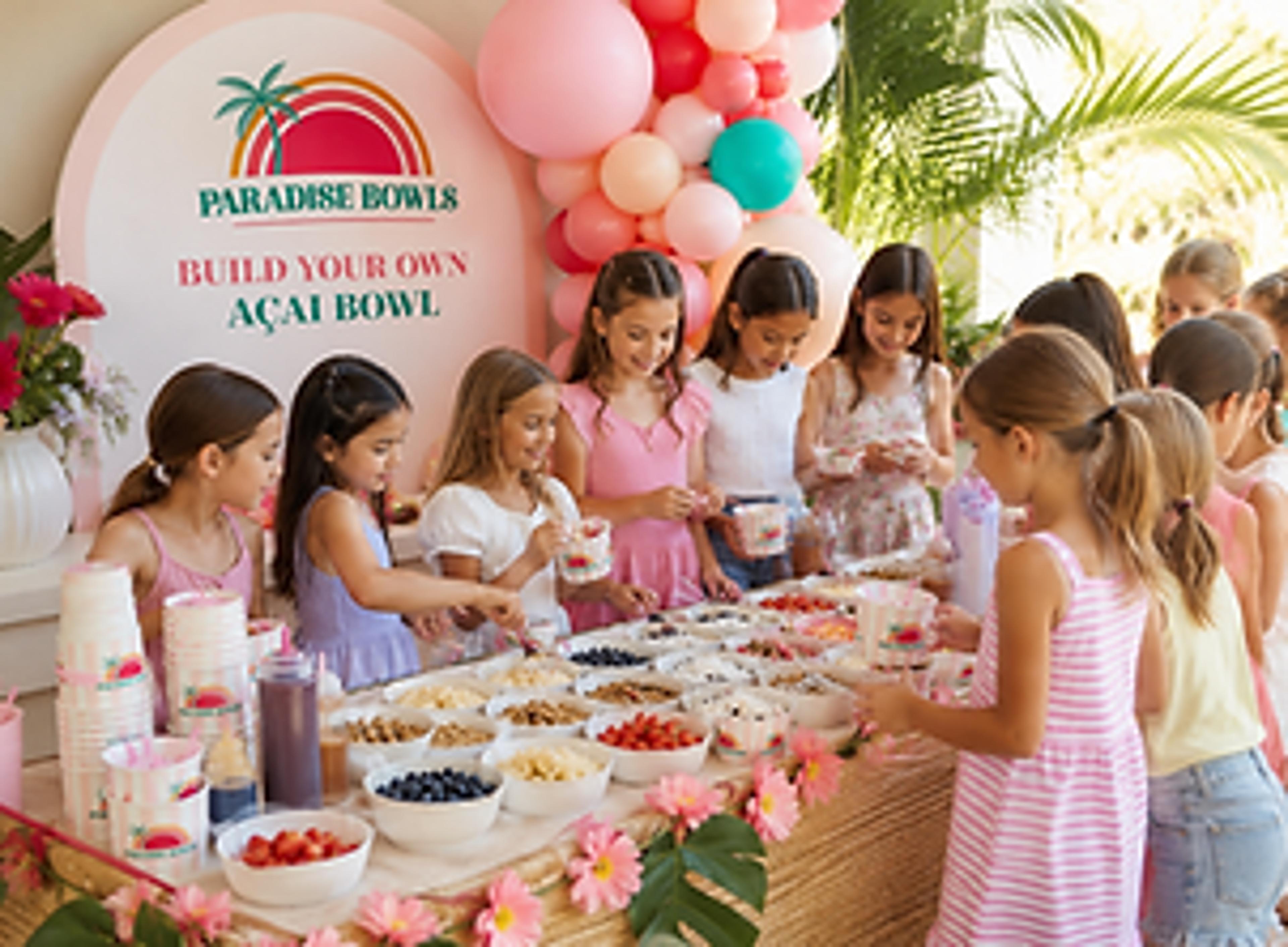 Birthday party guests choosing fruit and toppings at an açaí bowl bar