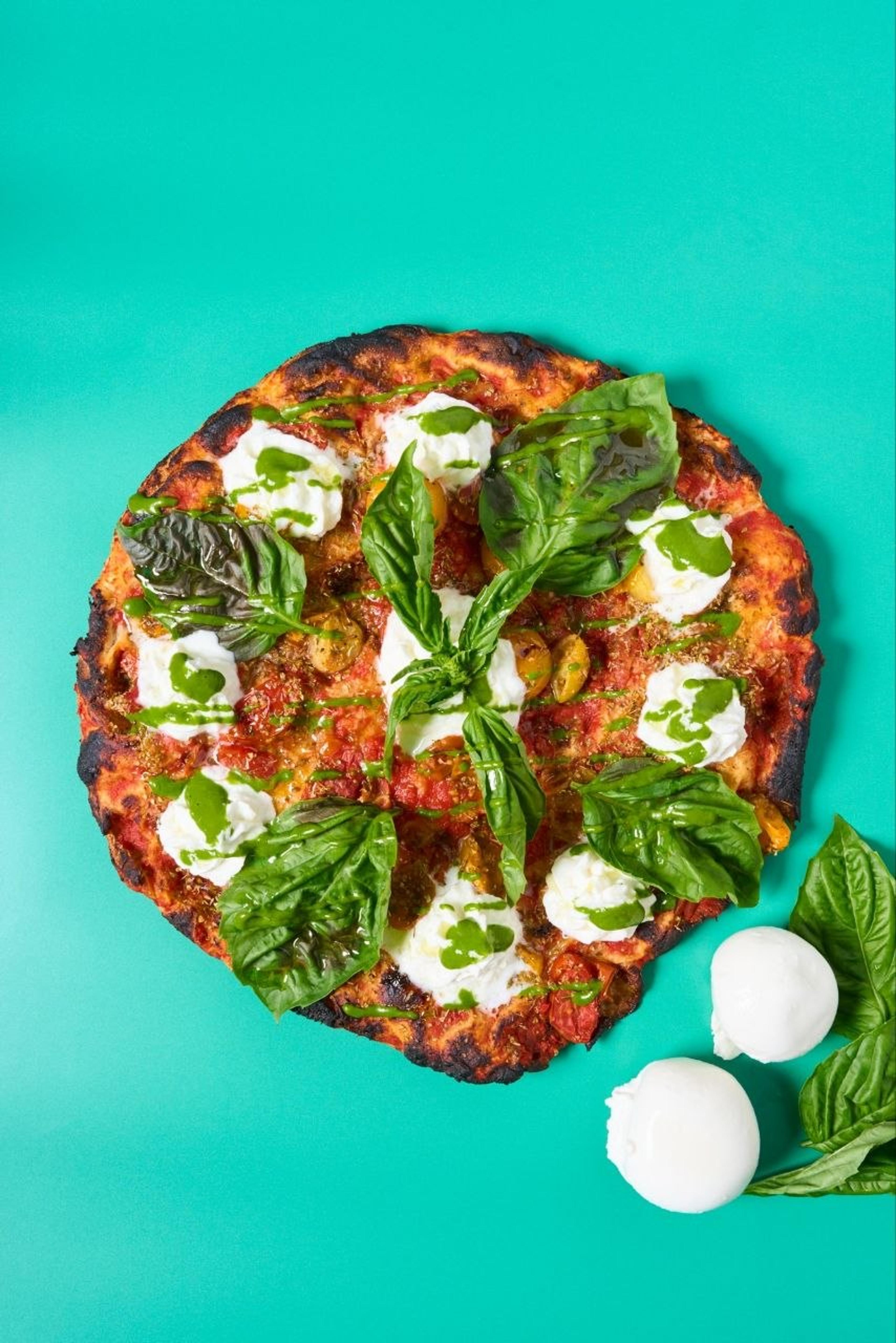 The Regina pizza with burrata, basil pesto and roasted heirloom tomatoes