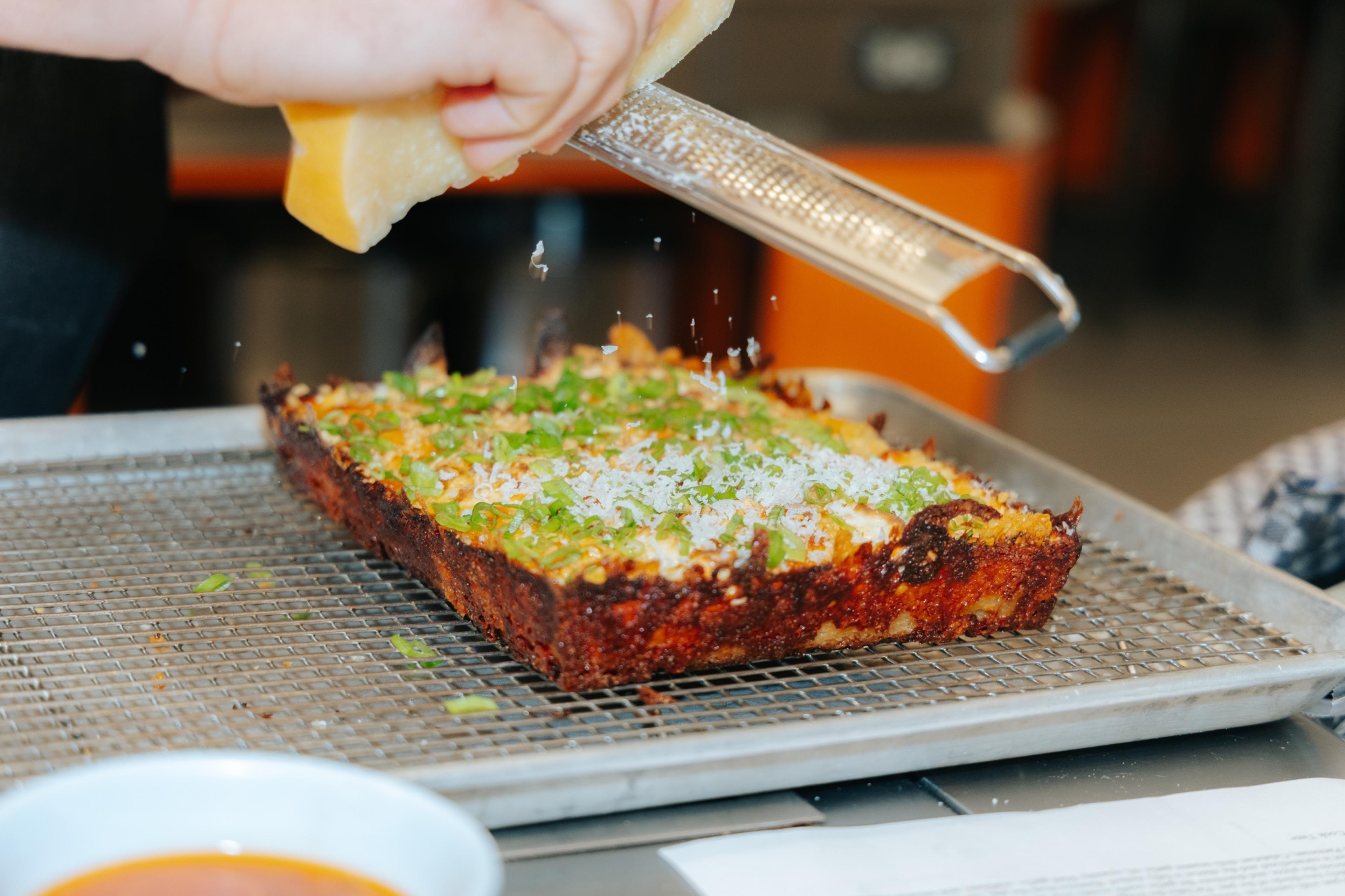 Dtown Pizzeria Detroit-style square pizza finished with scallions and parmesan