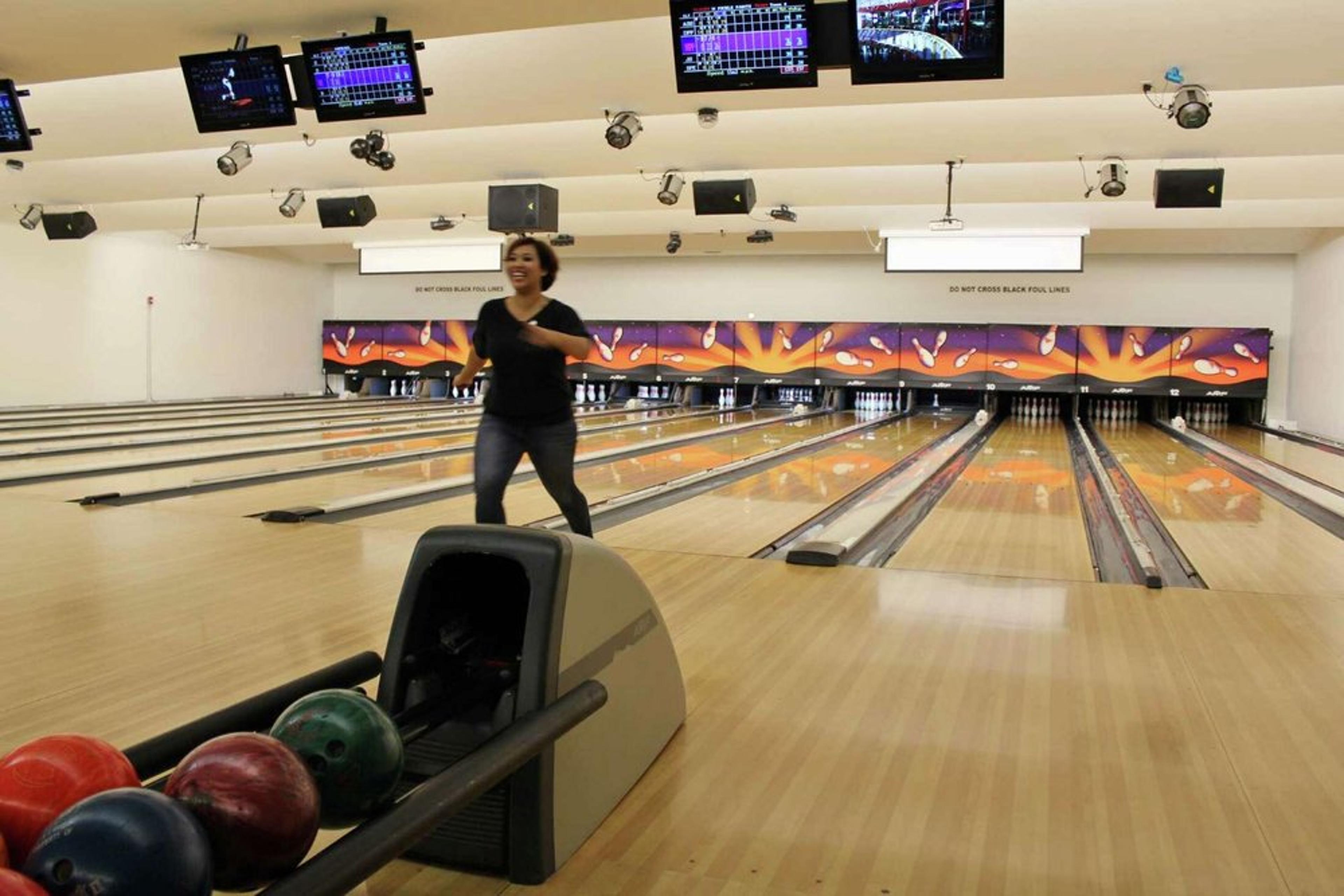 A bowler rolls a ball down the lanes at the Yerba Buena Bowling Center.