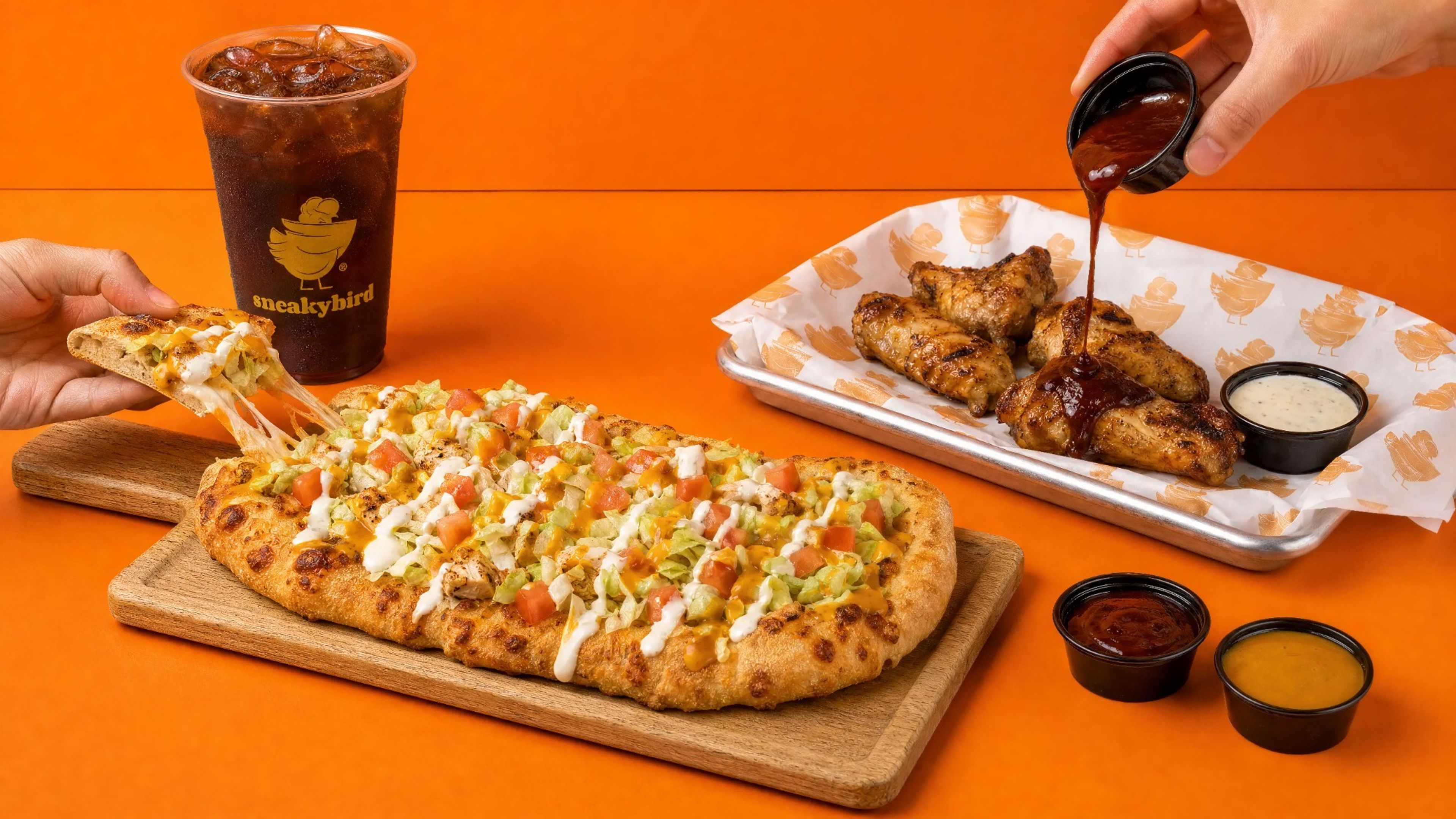 sneakybird flatbread with wings and a drink