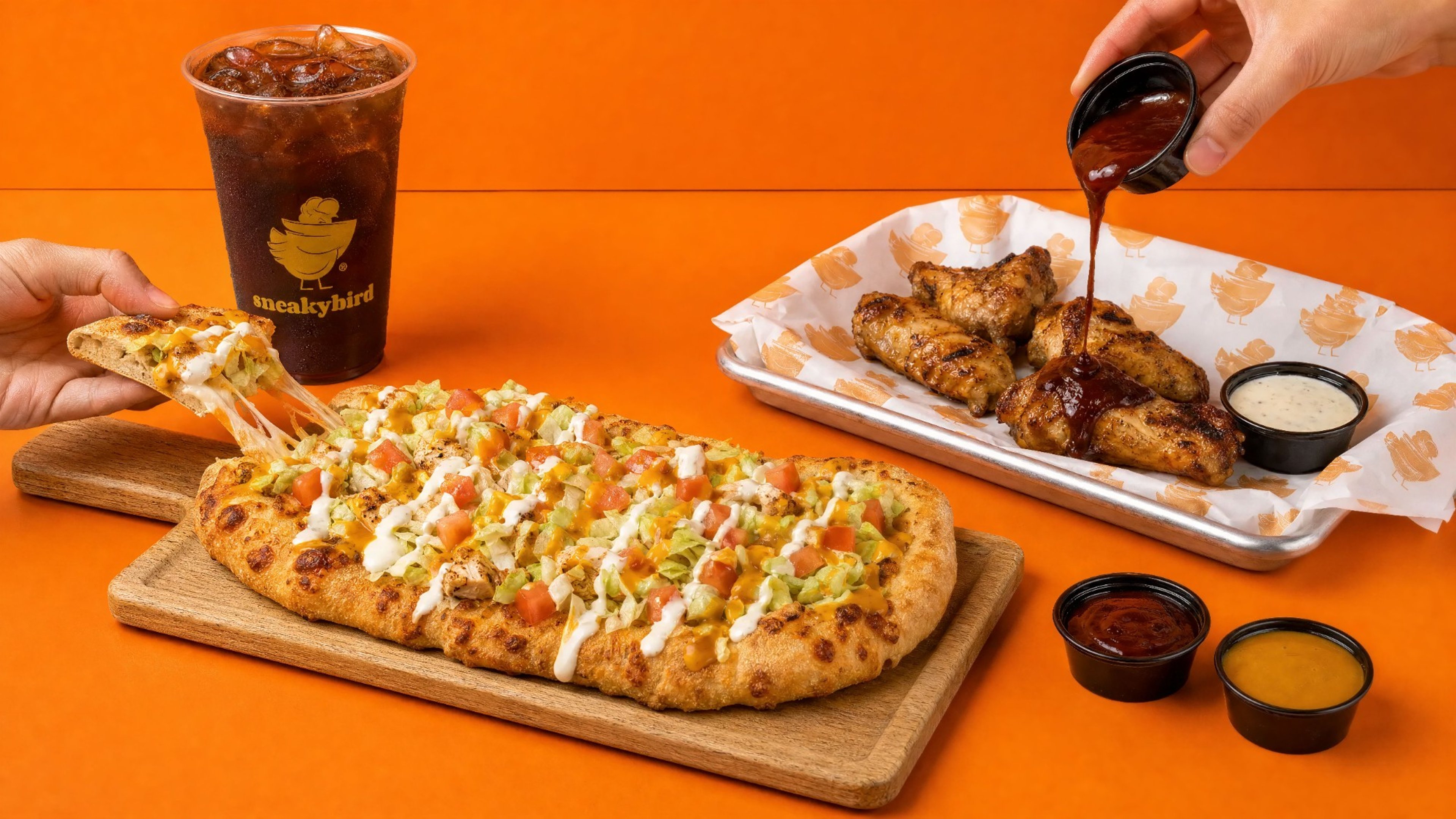 sneakybird flatbread with wings and a drink