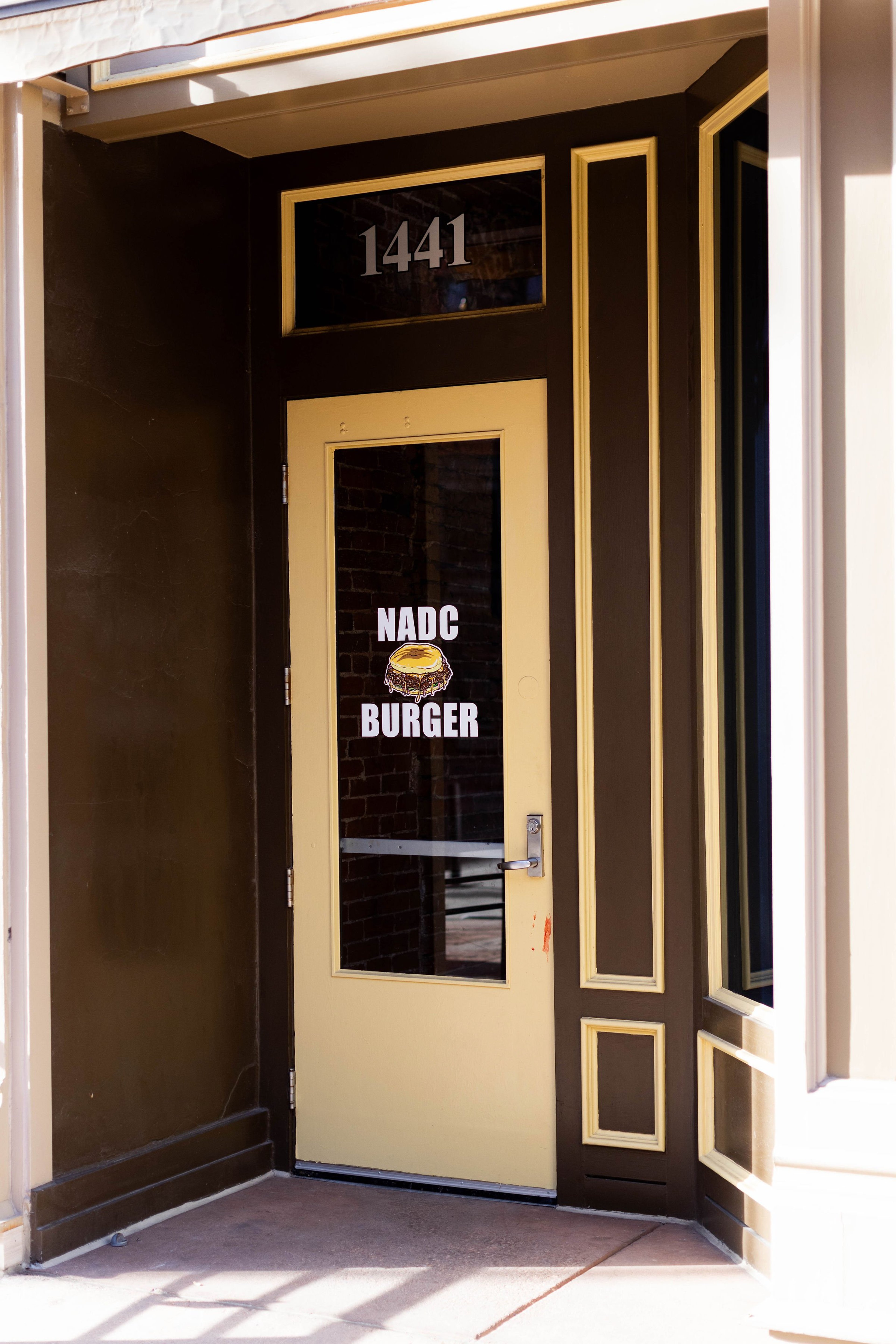 Door with NADC Burger signage at the Denver, Larimer Square location.