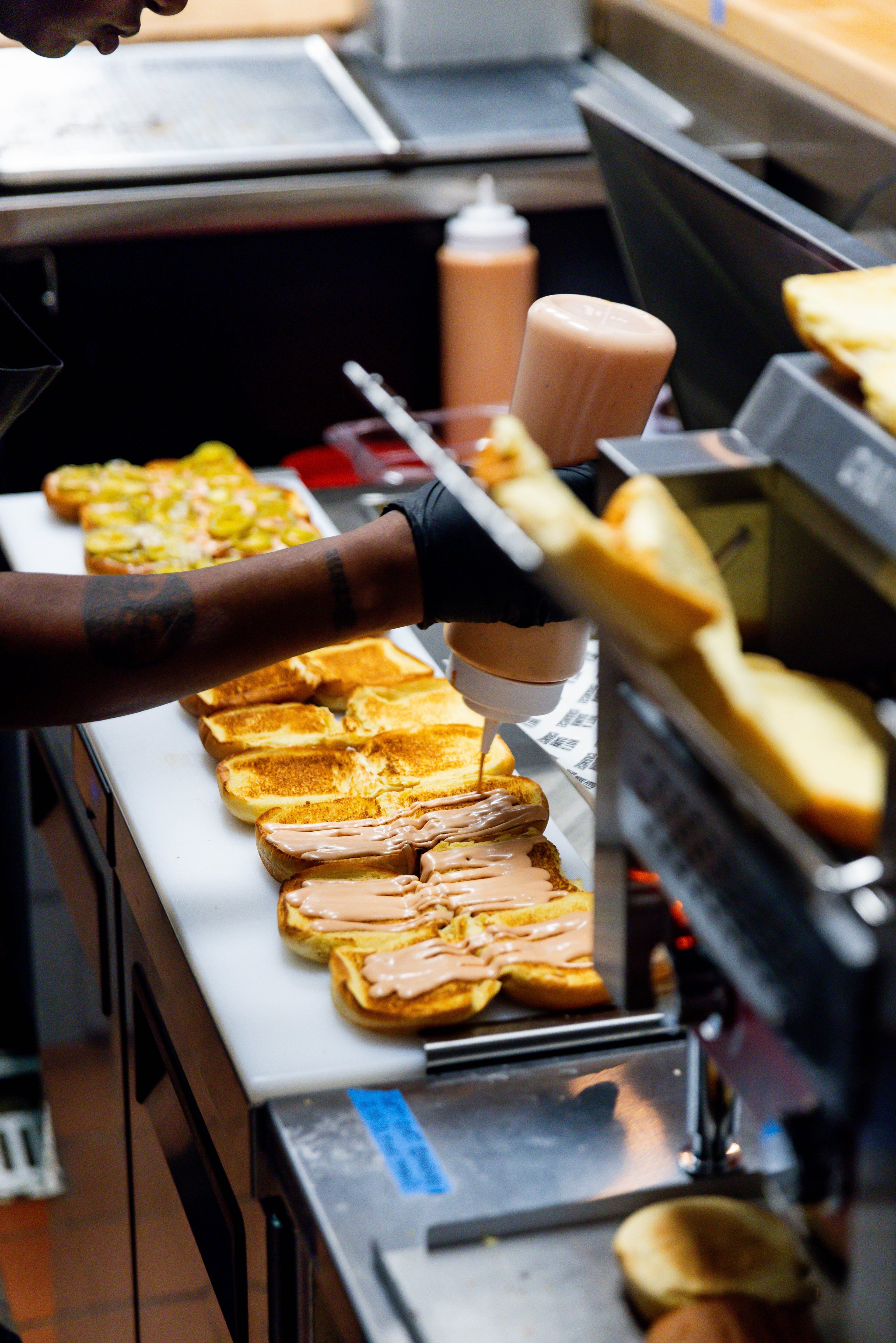 A cook preparing wagyu burgers at NADC Burger.