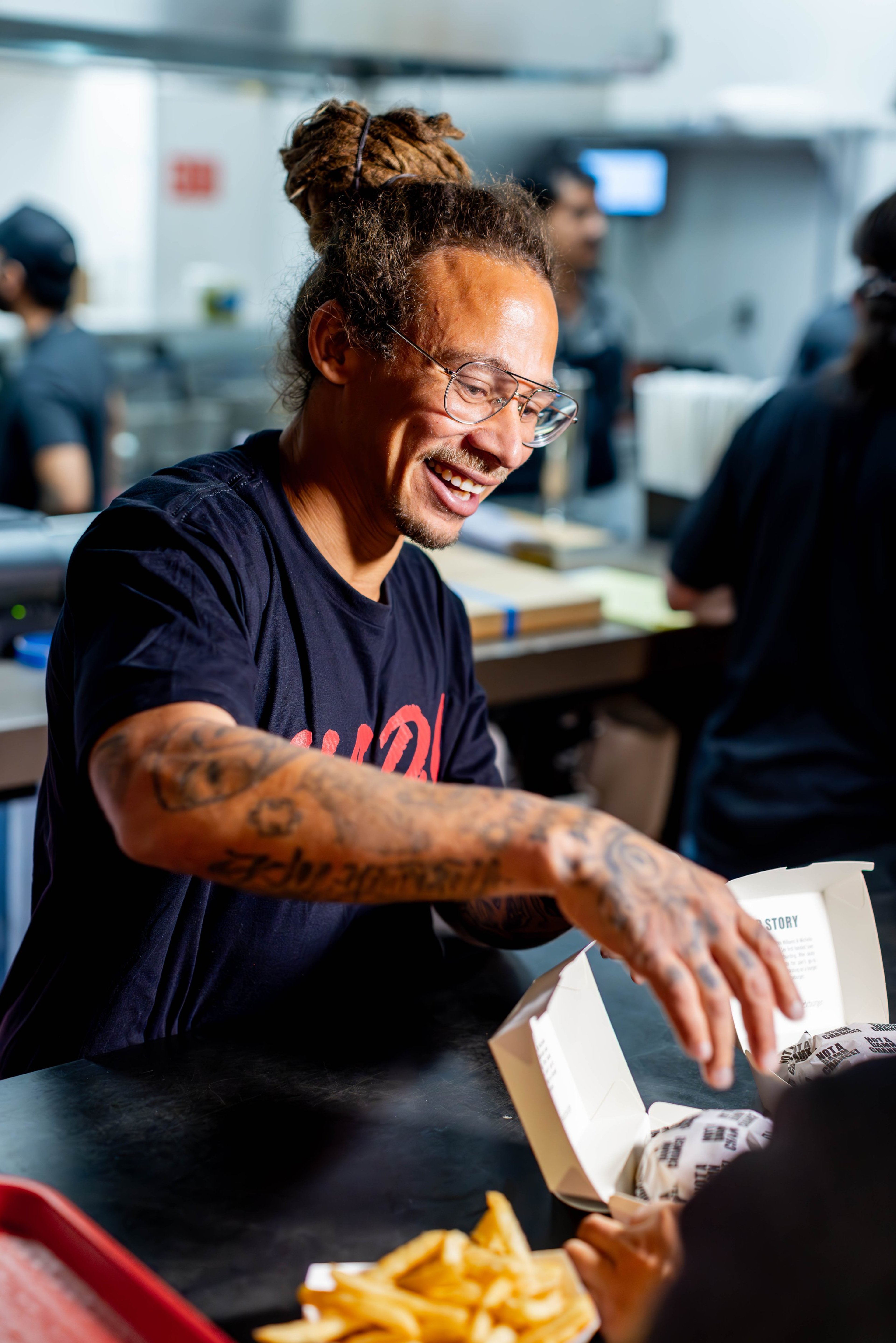 Neen Williams, co-owner of NADC Burger, serves burgers at the Denver location in Larimer Square.