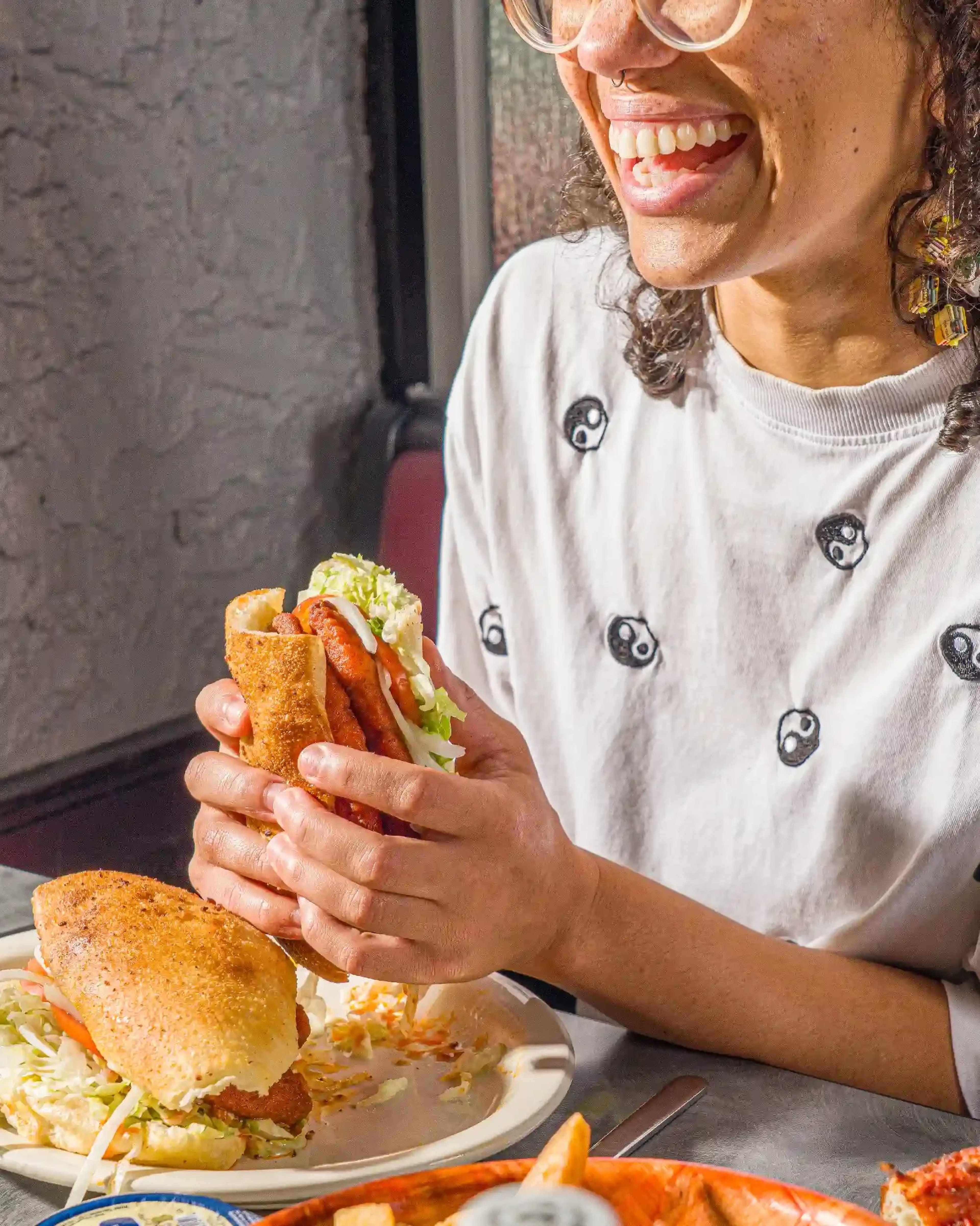 Woman eating a sub from Picasso's Pizza.