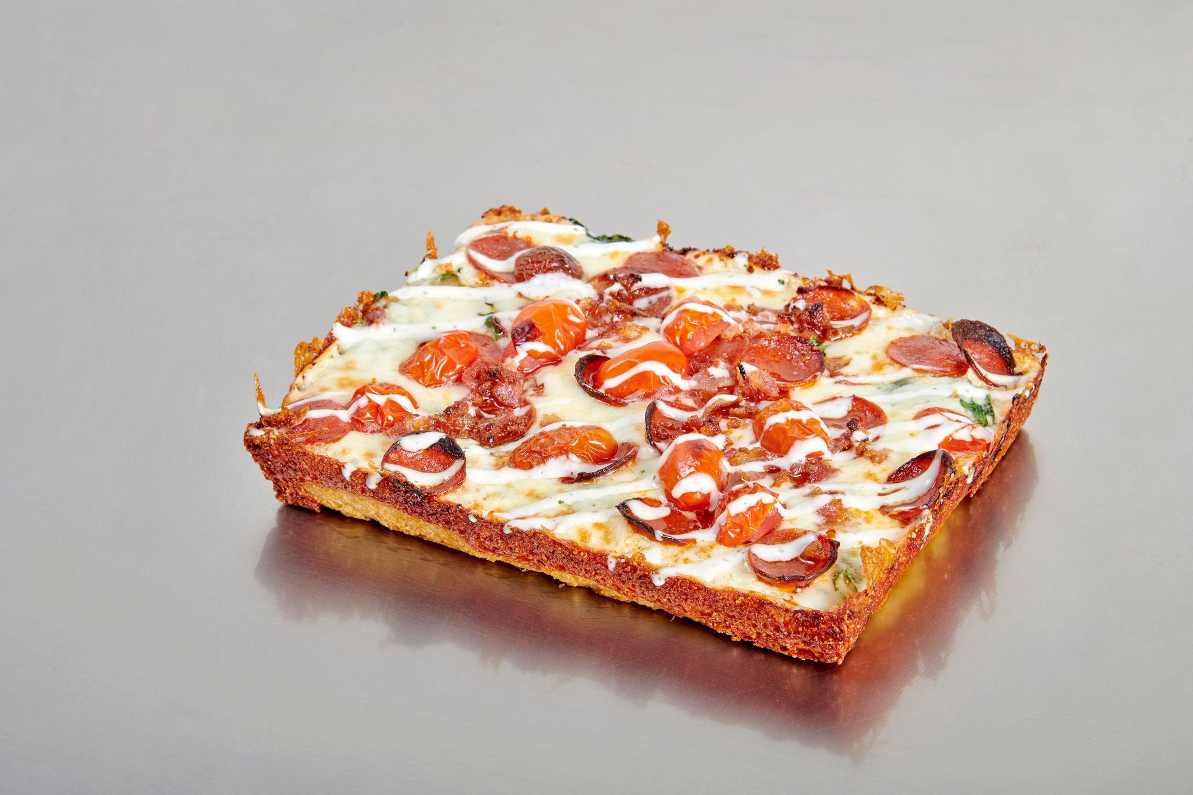 Close-up of a Detroit-style pizza from The Ria Pizzeria