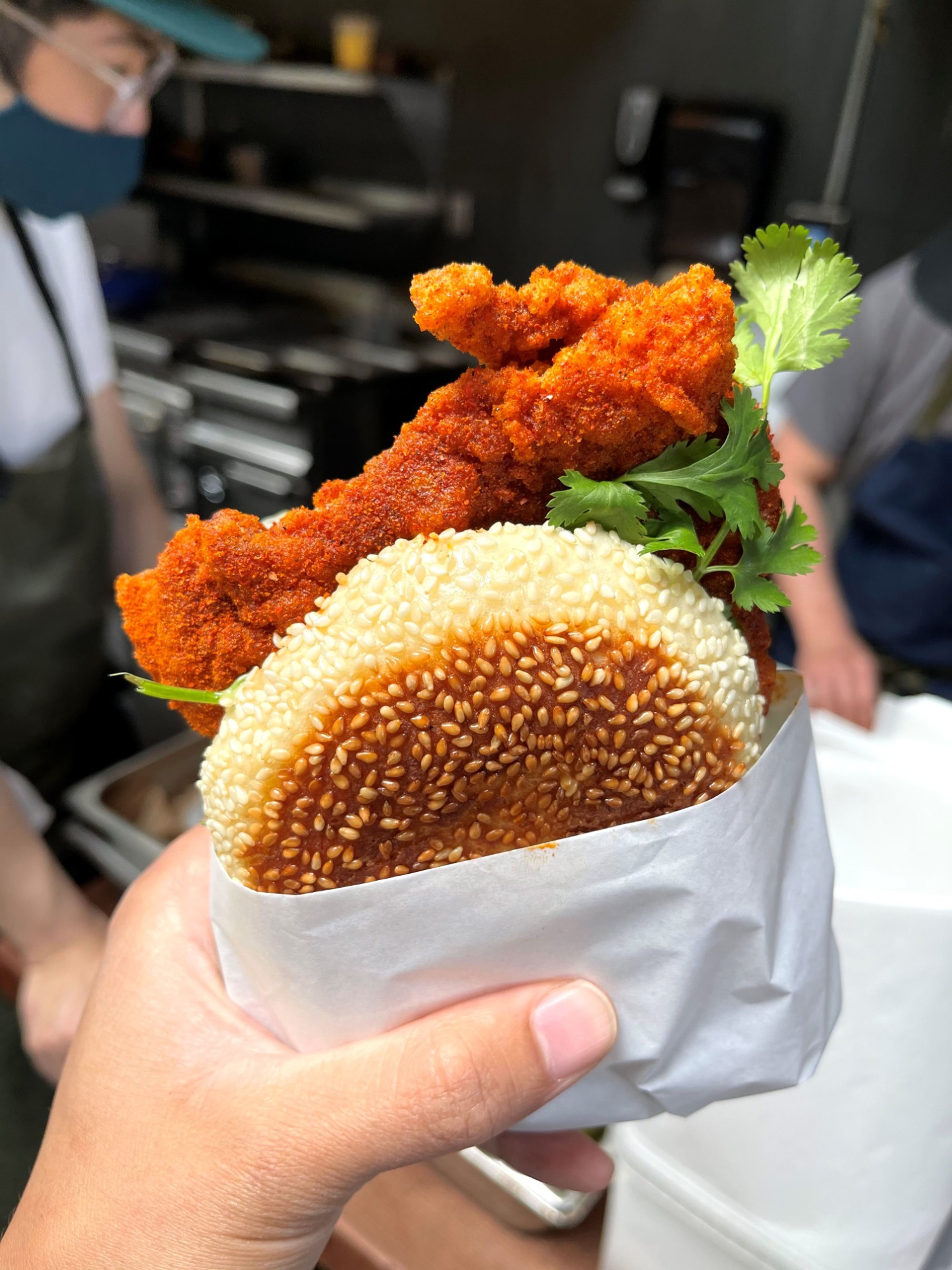 Ok's Deli Sichuan hot chicken sando on a sesame bun with cilantro