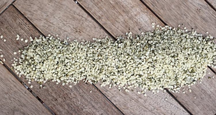 Hemp seeds spilled across a wooden table